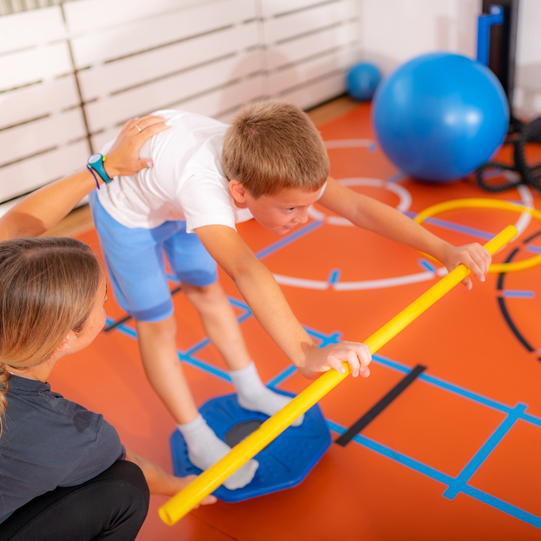 A child practising balance with a therapist